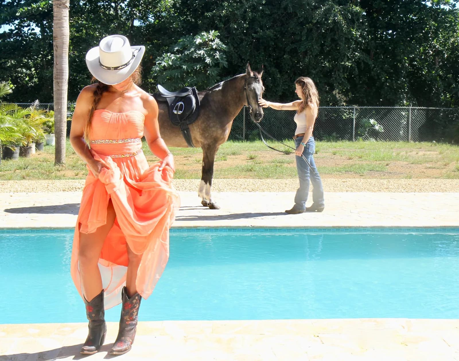 A handler holding the horse while a model poses at the poolside